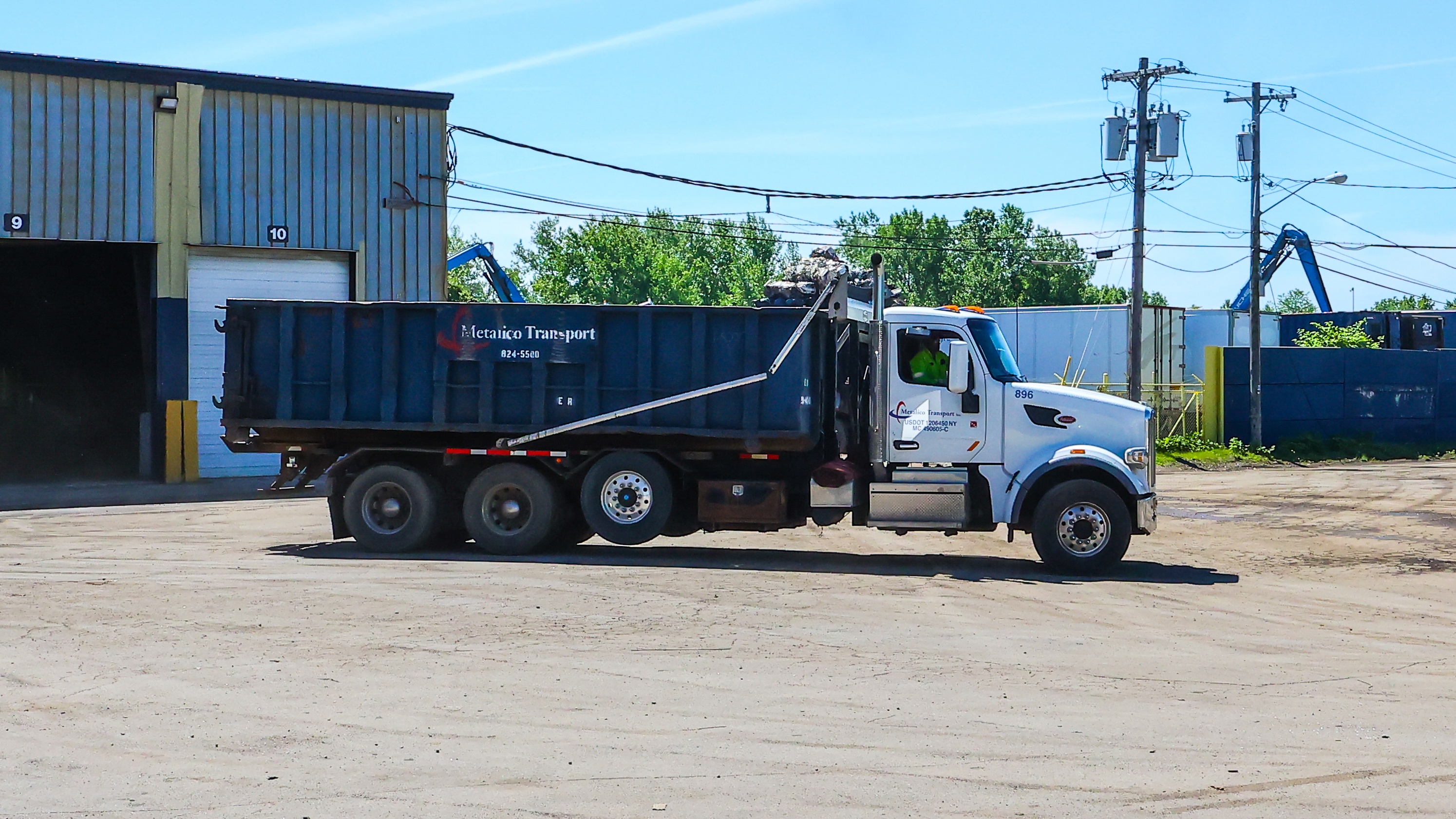 Scrap container pickup truck at worksite in Buffalo